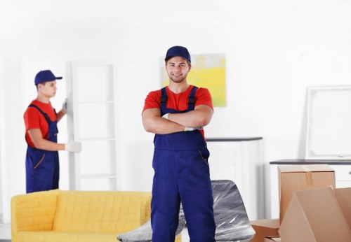 Local movers carrying items down stairs in a Crystal Palace flat